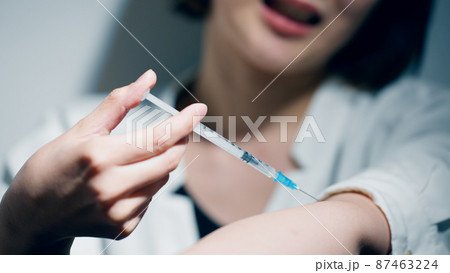注射器を打つ若い女性　薬物依存イメージ	 87463224