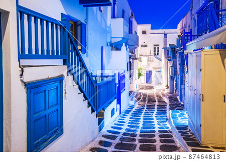 Mykonos, Greece - Cobblestone alley whitewashed village Cyclades Islands night view Mykonos, Greece - Cobblestone alley whitewashed village Cyclades Islands night view 87464813