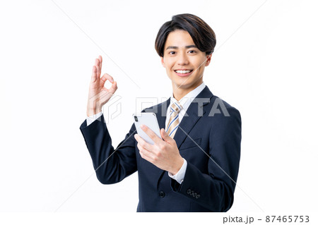 白バックでスマホを見る若いビジネスマンの男性 87465753