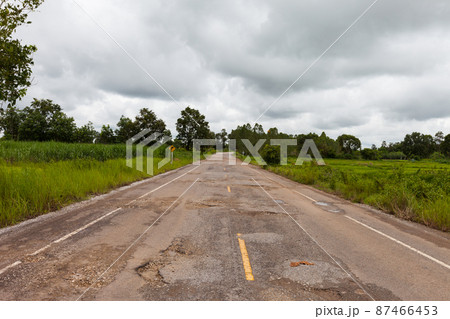 Damaged asphalt pavement road with potholes 87466453