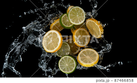 Freeze motion of sliced limes and lemons in water splash. 87466858