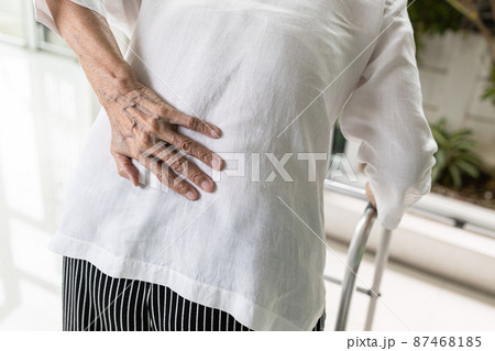 Asian senior woman with lower back pain or back muscle injury,old elderly having backache,inflammation and degeneration of muscle tissue and intervertebral discs or autoimmune diseases,health problems 87468185