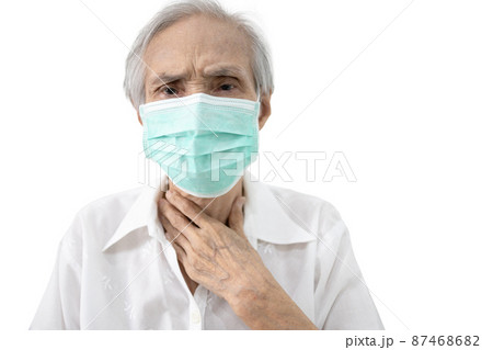 Sick old elderly in a medical protective mask,touch her neck pain,Asian senior woman have a fever,feel a sore throat,side effects from Coronavirus infection,COVID-19 Delta,Omicron variants outbreak 87468682