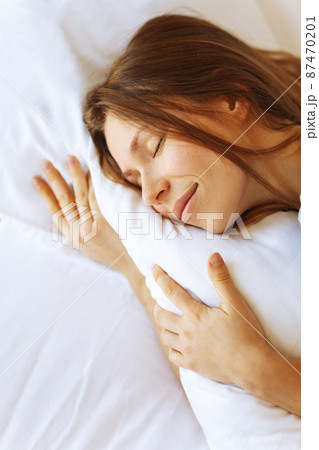 Portrait of young woman enjoying sleeping time in bed , close up ,elevated view, hugging pillow. Portrait of young woman enjoying sleeping time in bed , close up ,elevated view, hugging pillow. 87470201