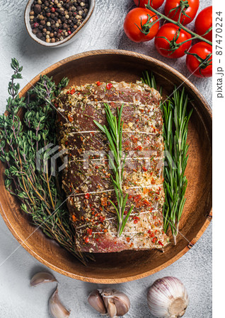 Raw italian Porchetta seasoned with herbs, pork meat roll. White background. Top view 87470224