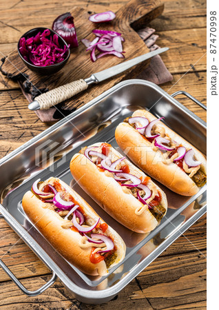 Vegan Vegetarian hot-dogs with onion and meatless sausage. Wooden background. Top view Vegan Vegetarian hot-dogs with onion and meatless sausage. Wooden background. Top view 87470998