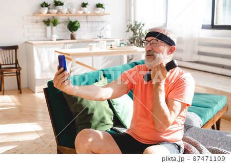 Senior man taking selfie for social network during doing fitness exercises with dumbbells - wellbeing and technology concept 87471109