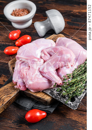 Raw hare legs on a butcher board with thyme. Dark wooden background. Top view 87471152
