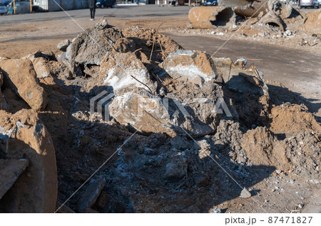 A crumbled concrete structure. A pile of pieces of iron-concrete, rebar and stones. Daytime. Outside. A crumbled concrete structure. A pile of pieces of iron-concrete, rebar and stones. Daytime. Outside. 87471827