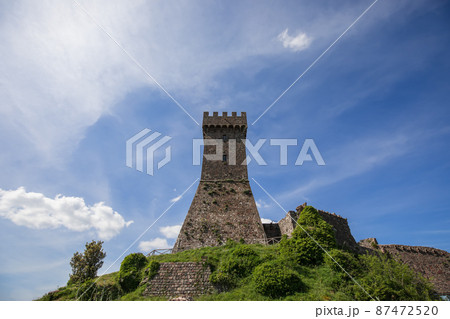 Brick tower Rocca of Radocofani with the cloudy sky background on a summer day, Tuscany, Italy Brick tower Rocca of Radocofani with the cloudy sky background on a summer day, Tuscany, Italy 87472520