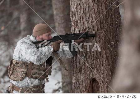 Soldier in winter camouflaged uniform in Modern warfare army on a snow day on forest battlefield with a rifle. Model face very similar to Ukraine prime minister. Soldier in winter camouflaged uniform in Modern warfare army on a snow day on forest battlefield with a rifle. Model face very similar to Ukraine prime minister. 87472720