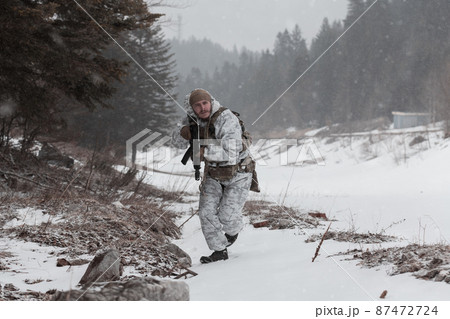Soldier in winter camouflaged uniform in Modern warfare army on a snow day on forest battlefield with a rifle. Model face very similar to Ukraine prime minister. Soldier in winter camouflaged uniform in Modern warfare army on a snow day on forest battlefield with a rifle. Model face very similar to Ukraine prime minister. 87472724