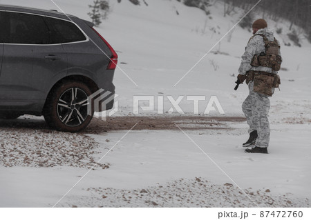 Soldier in winter camouflaged uniform in Modern warfare army on a snow day on forest battlefield with a rifle. Model face very similar to Ukraine prime minister. 87472760
