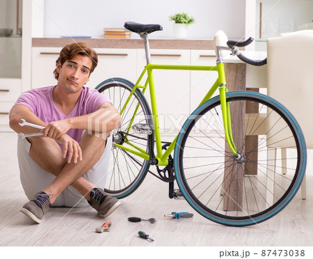 The man repairing his broken bicycle 87473038