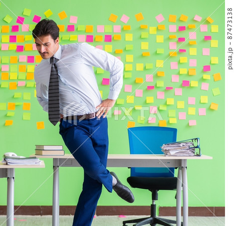 Man in the office with many conflicting priorities doing exercis 87473138