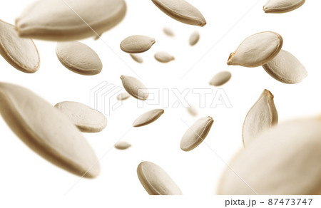 Pumpkin seeds levitate on a white background 87473747