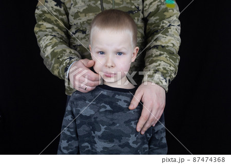War in Ukraine. Military and children. Ukrainian soldier hugs a child. Army protects country population from invaders. Terrorist activities in the country. Camouflage uniform of Ukrainian military War in Ukraine. Military and children. Ukrainian soldier hugs a child. Army protects country population from invaders. Terrorist activities in the country. Camouflage uniform of Ukrainian military 87474368