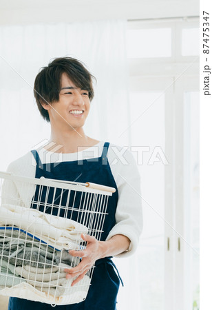 洗濯物を片付ける若い男性 洗濯物を片付ける若い男性 87475347