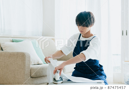 アイロンをかける若い男性 87475457