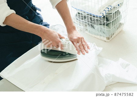 アイロンをかける若い男性 87475582