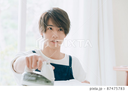 アイロンをかける若い男性 アイロンをかける若い男性 87475783