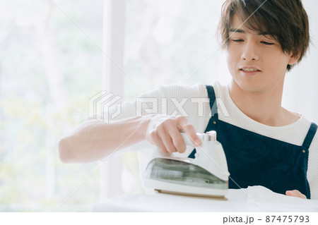 アイロンをかける若い男性 87475793