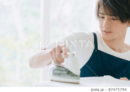 アイロンをかける若い男性 アイロンをかける若い男性 87475794