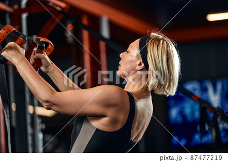 Women doing push ups training arms with trx fitness straps in the gym Concept workout healthy lifestyle sport 87477219