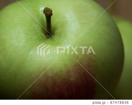 A large green apple, a close-up shot. A wet apple. 87478836