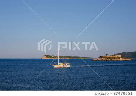 Sailboat sails past the Mamula island. Montenegro 87479551