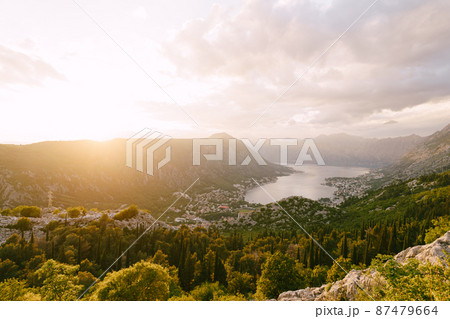 Sun sets behind the mountain range against the backdrop of the Bay of Kotor. Montenegro 87479664
