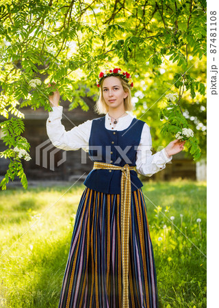 Latvian woman in traditional clothing posing on nature in village. Latvian woman in traditional clothing posing on nature in village. 87481108