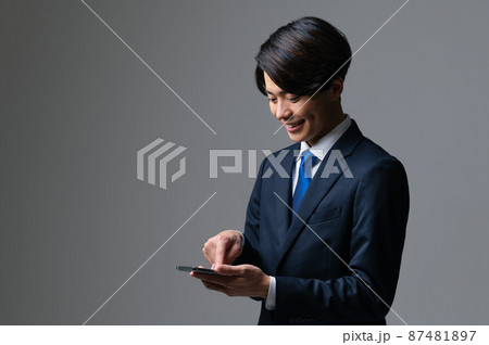スマートフォンを使う若いビジネスマン スマートフォンを使う若いビジネスマン 87481897