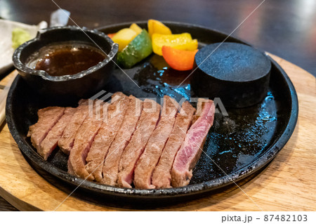 Beef medium rare steak sliced on hot stone pan 87482103