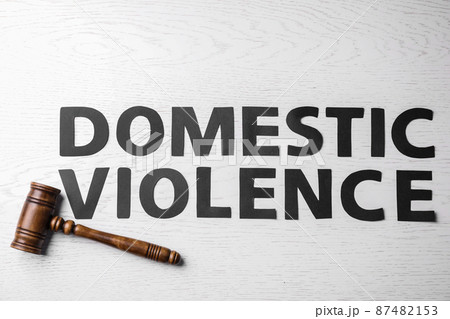 Words DOMESTIC VIOLENCE and gavel on white wooden table, flat lay 87482153