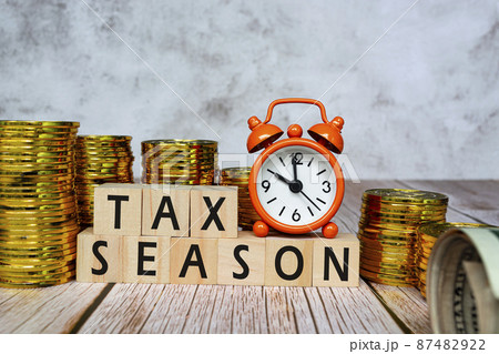 Text on wooden blocks and clock set at 10 o'clock with gold coins background. Text on wooden blocks and clock set at 10 o'clock with gold coins background. 87482922