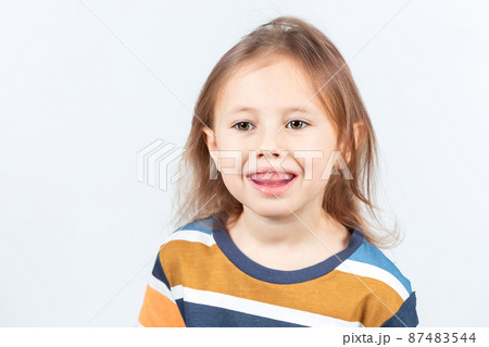 Little girl shows myofunctional trainer. dental tariner is made to correct bite 87483544