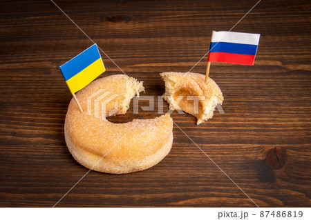 Ukrainian flag and the Russian flag inserted in a donut. Policy and territorial separation 87486819