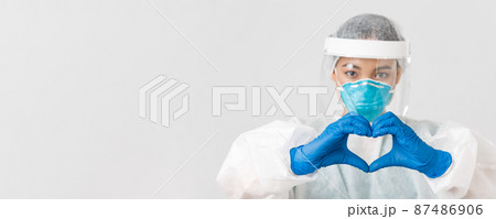 Covid-19, coronavirus disease, healthcare workers concept. Close-up of confident and caring asian female doctor in personal protective equipment, showing heart gesture to patients Covid-19, coronavirus disease, healthcare workers concept. Close-up of confident and caring asian female doctor in personal protective equipment, showing heart gesture to patients 87486906