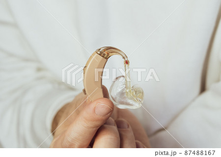 肌色の補聴器を持つ男性の手 肌色の補聴器を持つ男性の手 87488167