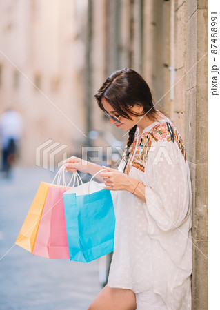 Young girl with shopping bags on narrow street in Europe. 87488991