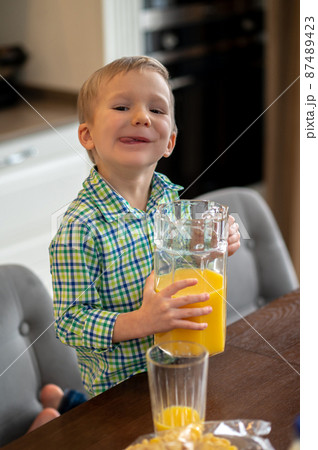 Kid with a glass jug posing for the camera 87489423