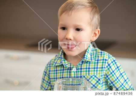 Kid with his tongue stuck out staring into the distance Kid with his tongue stuck out staring into the distance 87489436