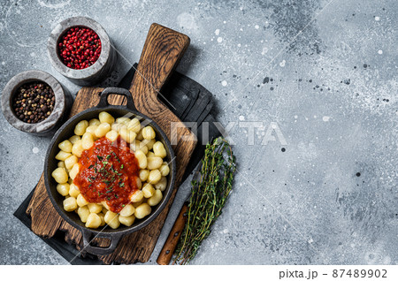 Gnocchi pasta with tomato sauce and parmesan. Gray background. Top view. Copy space 87489902