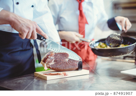 Detail shot of chef cook cutting Parma ham for use in a dish 87491907
