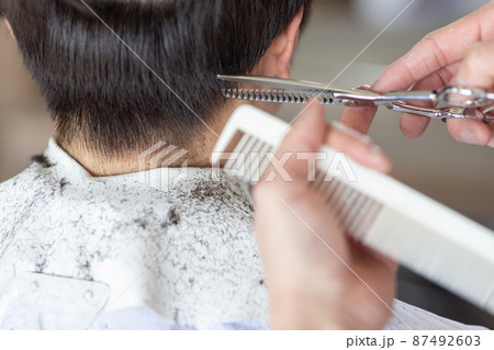 ヘアカットしてもらう男性 87492603