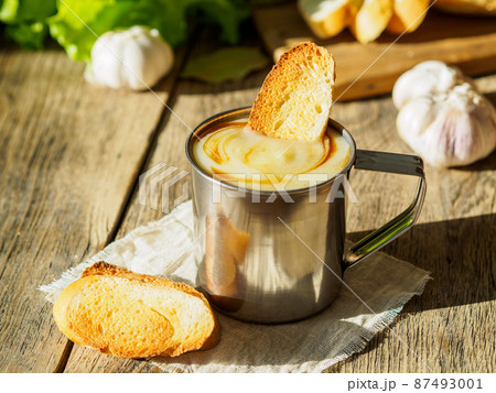 Simple diet is not fatty food, a small portion of cream soup mashed potatoes and cabbage in a metal mug, croutons. Side view, selective focus, daylight. 87493001