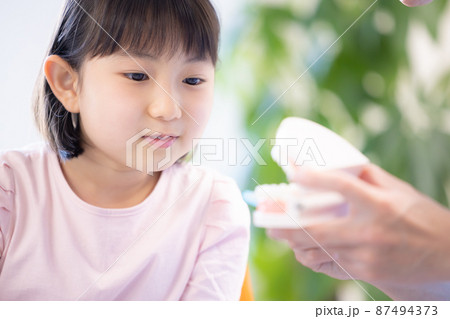 歯医者 歯磨き指導を受ける女の子 歯医者 歯磨き指導を受ける女の子 87494373
