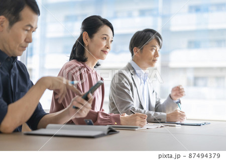 並んでメモをとる中高年の男女の横顔　会議・打ち合わせ・セミナー　イメージ　イメージ　 87494379