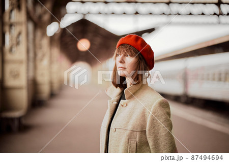 Close up portrait of beautiful woman, smiling and waiting for train on railway station. Girl travels light 87494694